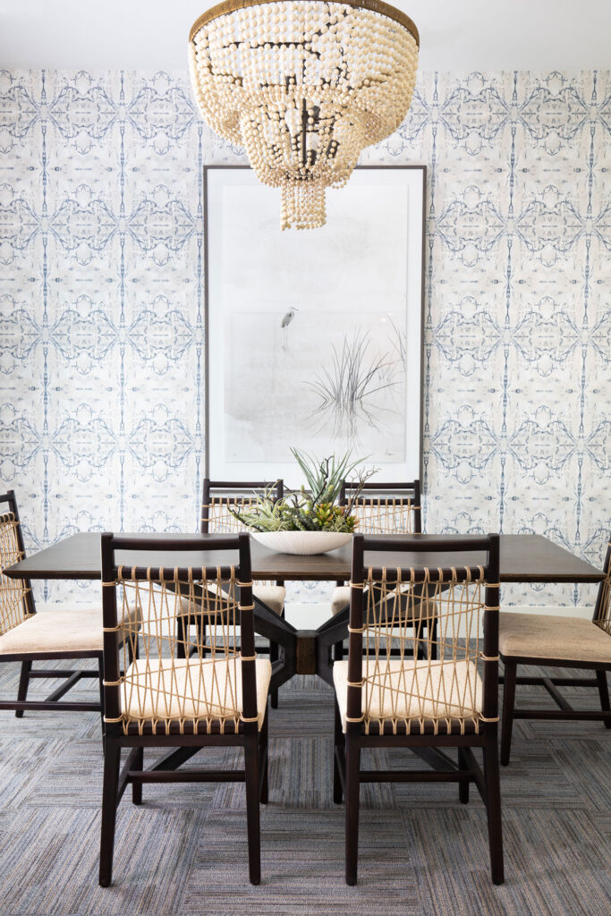 dining table with large art on all and chandelier