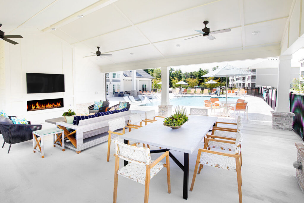 outdoor pool lounge with tvs, fireplace, and seating