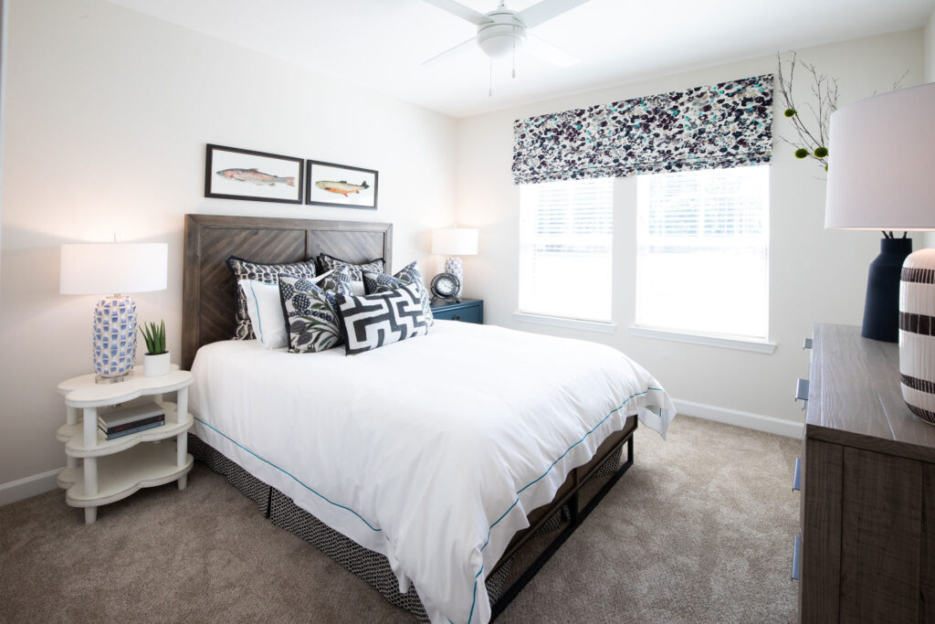 bedroom with view of window, wall art, and bed with decorative pillows