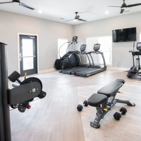 fitness center with equipment and tv's