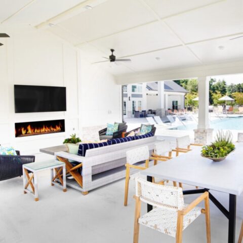 outdoor pool lounge with tvs, fireplace, and seating