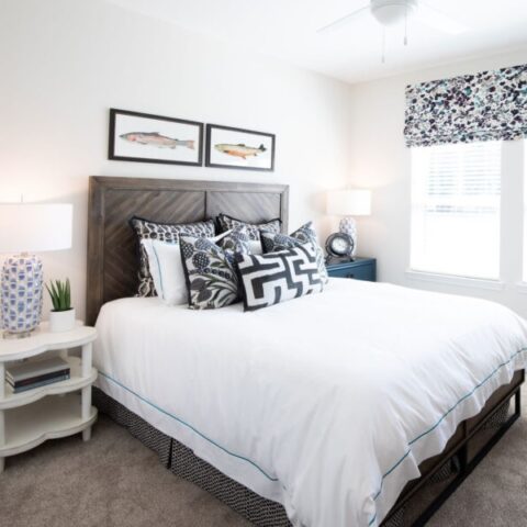bedroom with view of window, wall art, and bed with decorative pillows