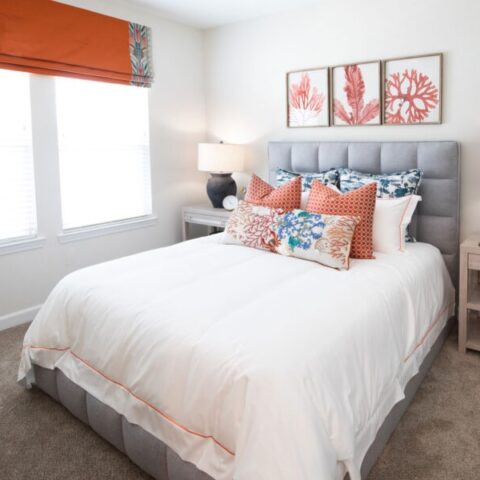 bedroom with wall art, bed, decorative pillows, and lamps